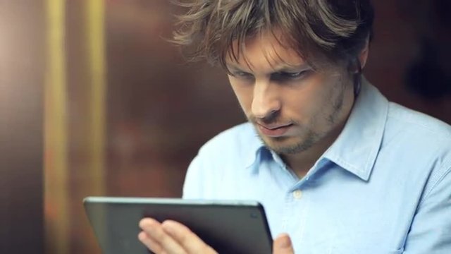 man using tablet computer touchscreen in cafe