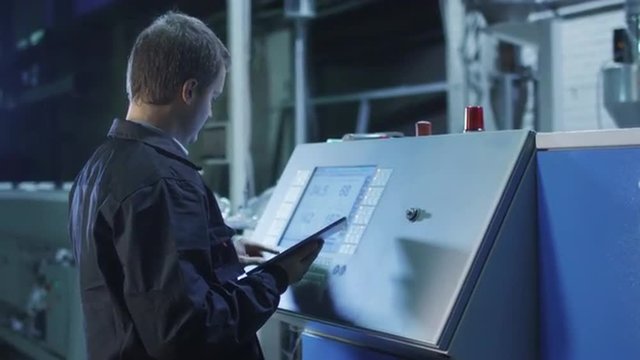 Factory Worker is Setting Up CNC Lathe Machine in Factory. Shot on RED Cinema Camera in 4K (UHD). Its easy scale, rotate and crop without loosing quality.