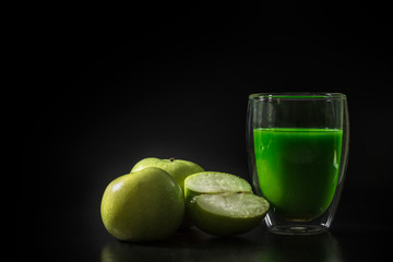 Green apple juice withe green apples on the black background