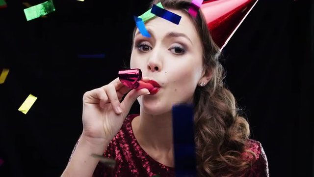 Cute girl wearing red blowing party blower slow motion photo booth