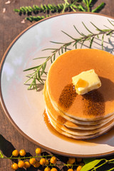 Stack of delicous pancake topped with butter and maple syrup