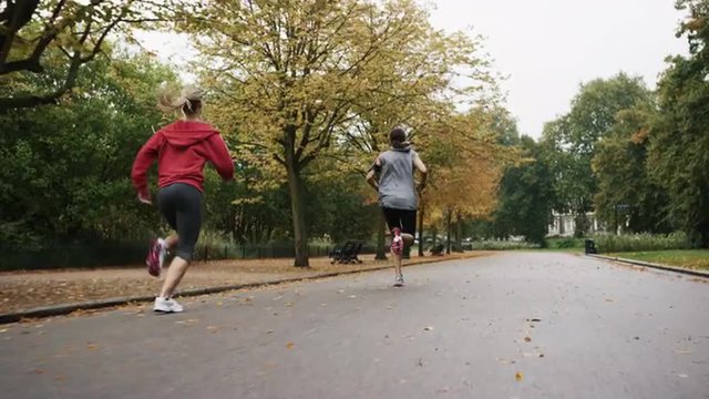 Group of runners running in park wearing wearable technology connected devices