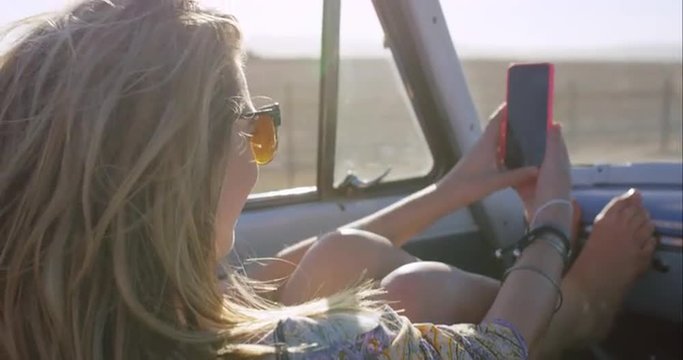 beautiful happy woman taking selfie on road trip in convertible car