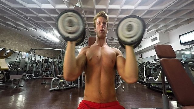 Body builder training with dumbbells in a gym
