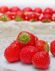 Red tomatoes and cream cake in background