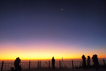 silhouette tourists photograph the sunrise