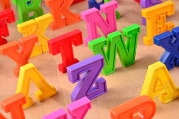 Fototapeta premium Plastic colorful alphabet letters on a wooden background