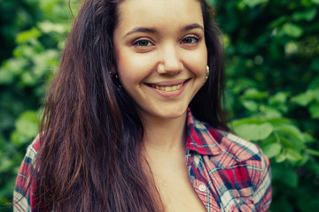 Fototapeta premium Brown hair girl sitting on the grass in the park and posing to the photo.