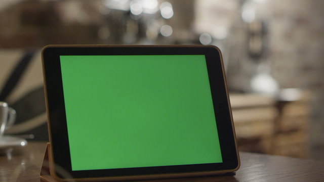 Tablet with Green Screen Staying on a Table.