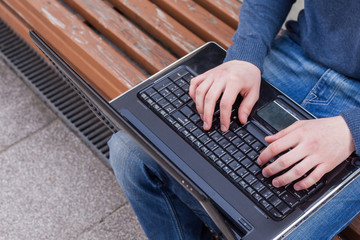 Fototapeta premium Image of man's hands typing. Selective focus. Outdoors photo.