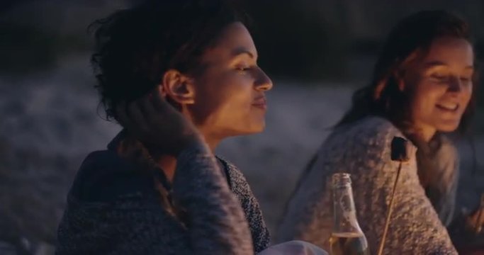 Beach Party at sunset with bonfire and roasting marshmellows with friends