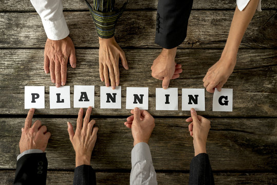 Eight business people assembling the word Planning