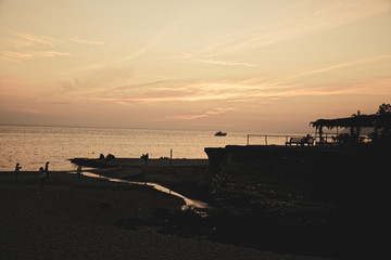 People on a rocky beach by the sea in the evening