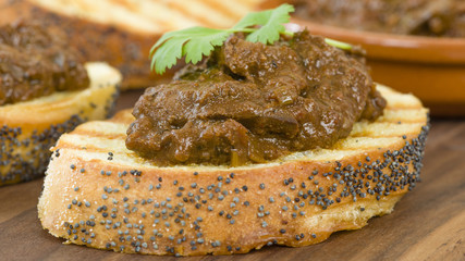 Higados de Pollo - Chicken livers with chorizo & spring onions finished with a dark Cajun tomato sauce on top of crusty bread.
