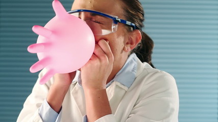 Pretty medical student blowing balloon with glove