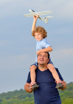 Father carrying son and his plane