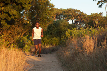 Fit young man running on path outdoors