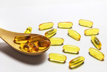 Fish oil capsules in the wood spoon