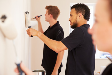 Decorating team painting a room in a house