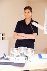 Portrait of female decorator posing with paint roller