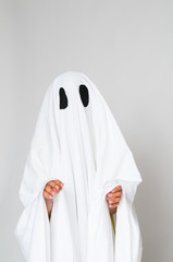 young child dressed in a ghost costume for Halloween