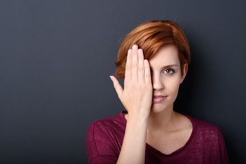 frau hält sich eine hand vor das auge