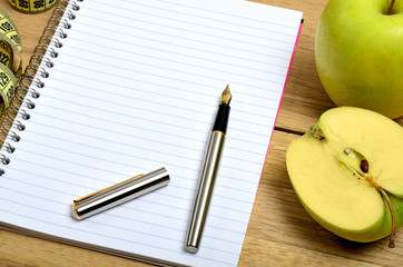 Open notebook with apple fruit