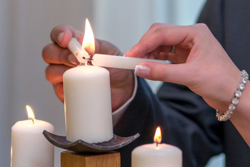 Couple lighting up candle as a symbol of love