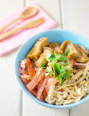 Chinese rice noodle roll with egg, chinese sausage, tofu (Kuay Teow Lod)  on blue bowl and white wood table