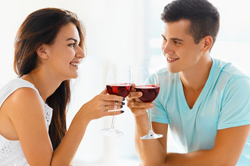 Fototapeta na wymiar Couple clinking their glasses of red wine.