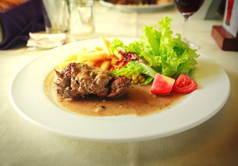 Grilled steak with french fries and salad