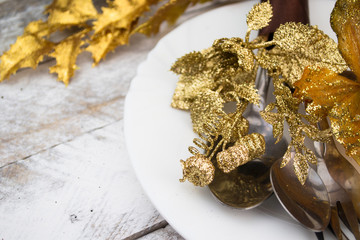 Christmas table setting in gold and brown tone on wooden table