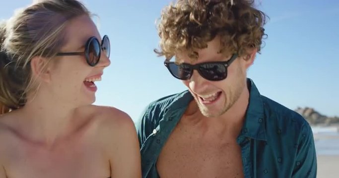 beautiful Caucasian couple taking selfies on the beach man with open shirt