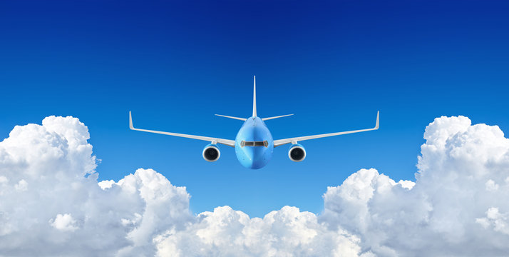 Passenger airplane flying in the blue sky among the clouds