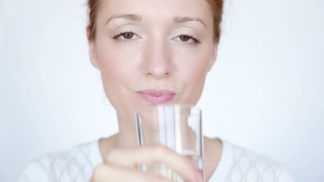 Woman drinks water and smiling