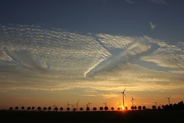 Windpark im Aufbau bei Sonnenuntergang mit Cirrocumuluswolken und Fallstreak-Muster