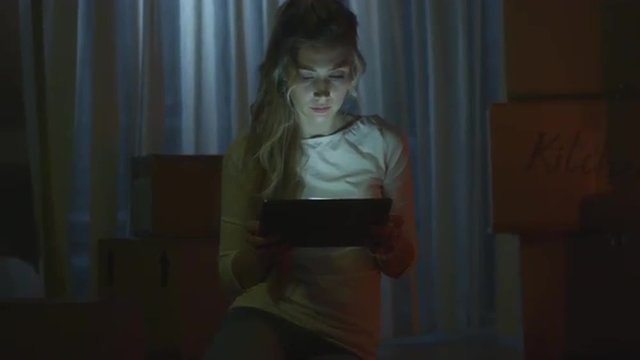 Girl is Using Tablet in New House at Night