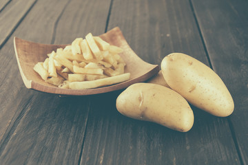 french fries on wood background - soft focus with vintage film f