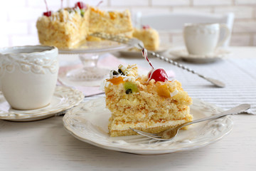 Peace of tasty Butter cake on plate, tea cups on color wooden background