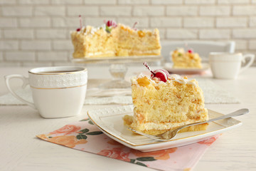 Peace of tasty Butter cake on plate, tea cups on color wooden background