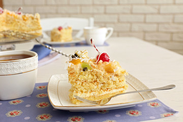 Peace of tasty Butter cake on plate, tea cups on color wooden background