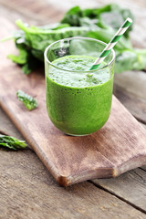 Glass of spinach juice on wooden table, closeup