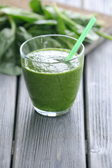 Glass of spinach juice on wooden table, closeup
