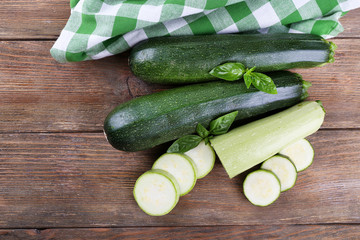 Fresh zucchini with squash and basil on wooden table close up