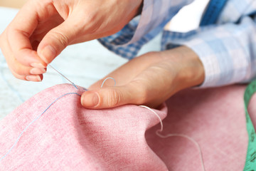 Obraz na płótnie Canvas Closeup hands of seamstress at work with cloth fabric