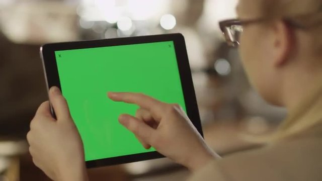 Girl Using Tablet with Green Screen in Landscape Mode in Coffee Shop