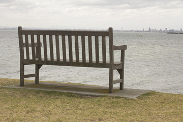 Fototapeta na wymiar Alone Wood Bench and view to the Sea Landscape. Melbourne, Australia.