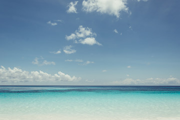 blue sky with sea and beach - soft focus with film filter