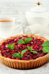 Tart with raspberries and tasty tea, on color  wooden background