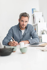 Portrait of a nice grey hair man with beard, working at home on